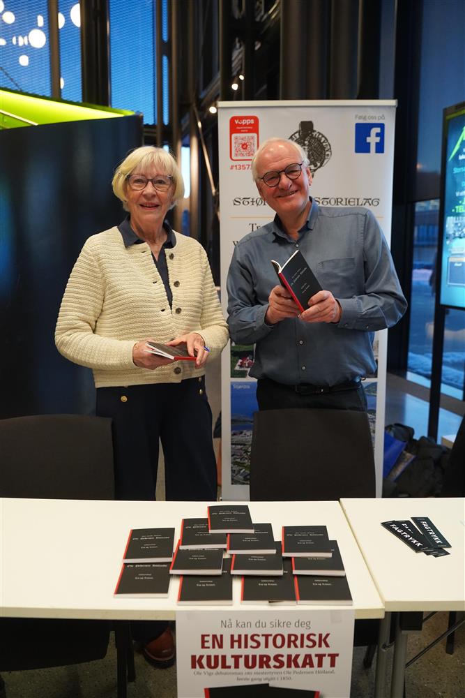To eldre personer, en mann og en dame som står på stand på Kimen for å selge eksemplarer av Ole Vig sin første bok - Klikk for stort bilde