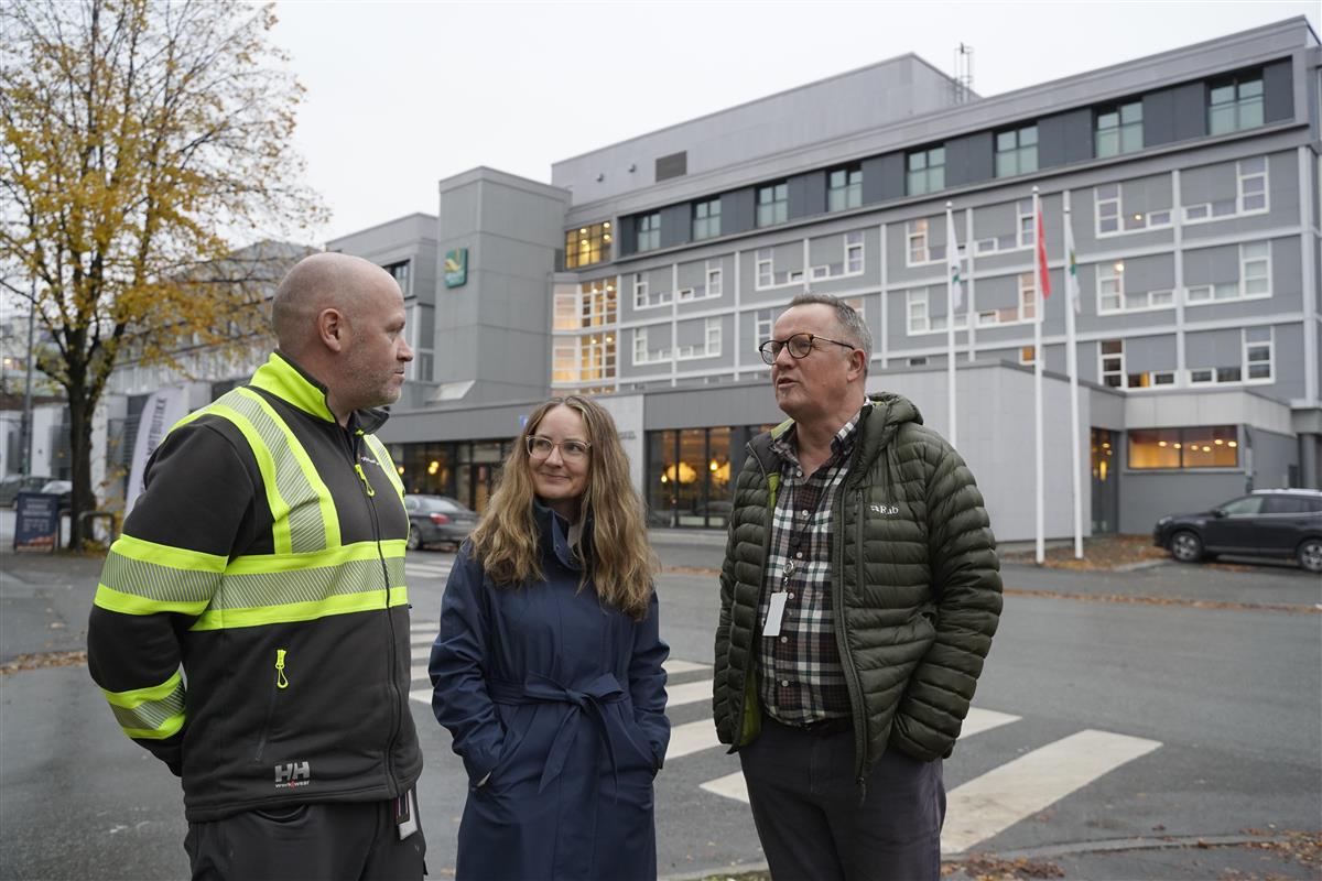 Tre personer som står utendørs ved et veikryss i Stjørdal - Klikk for stort bilde