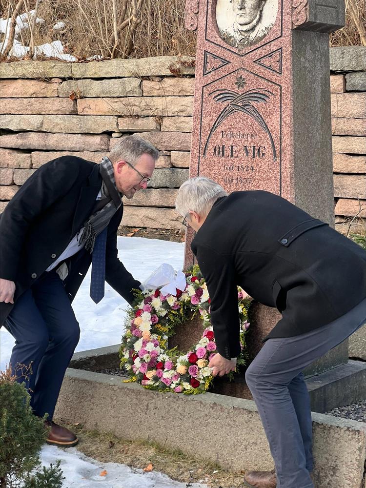 Kommunedirektøren og leder for utdanningsforbundet legger ned kransen på Ole Vig sin grav. - Klikk for stort bilde