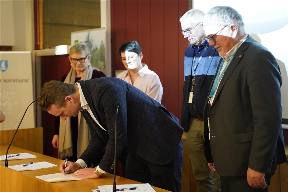 CEO fra Aidn skriver under på kontraktene. - Klikk for stort bilde