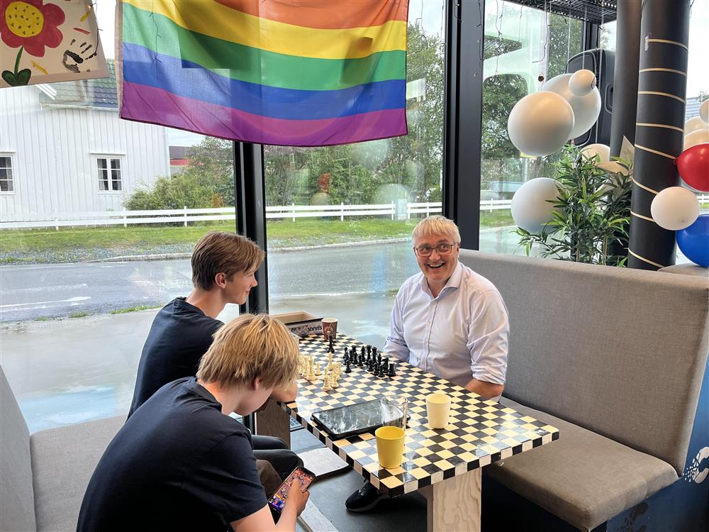 Kommunedirektør Tor Jakob sammen med to ansatte fra Carbon fritidsklubb, de sitter rundt et bord og spiller sjakk. - Klikk for stort bilde