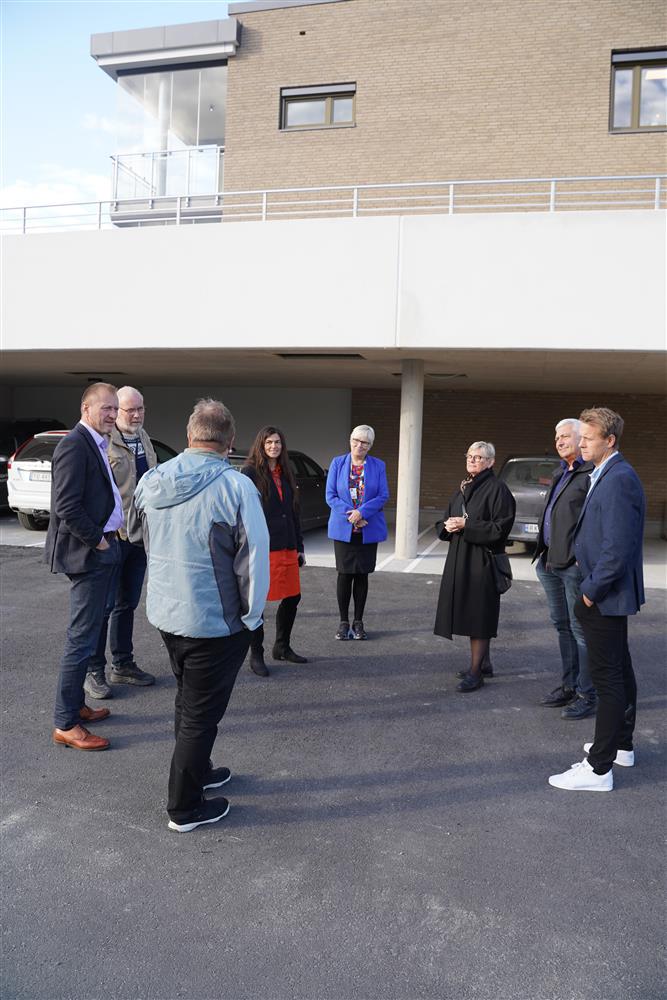 6 av medlemmene i Formannskapet samt Jan Torstein Ovidth står utenfor parkeringsgarasjen. De står i en halv sirkel og hører på Jan Torstein fortelle om prosjektet. - Klikk for stort bilde