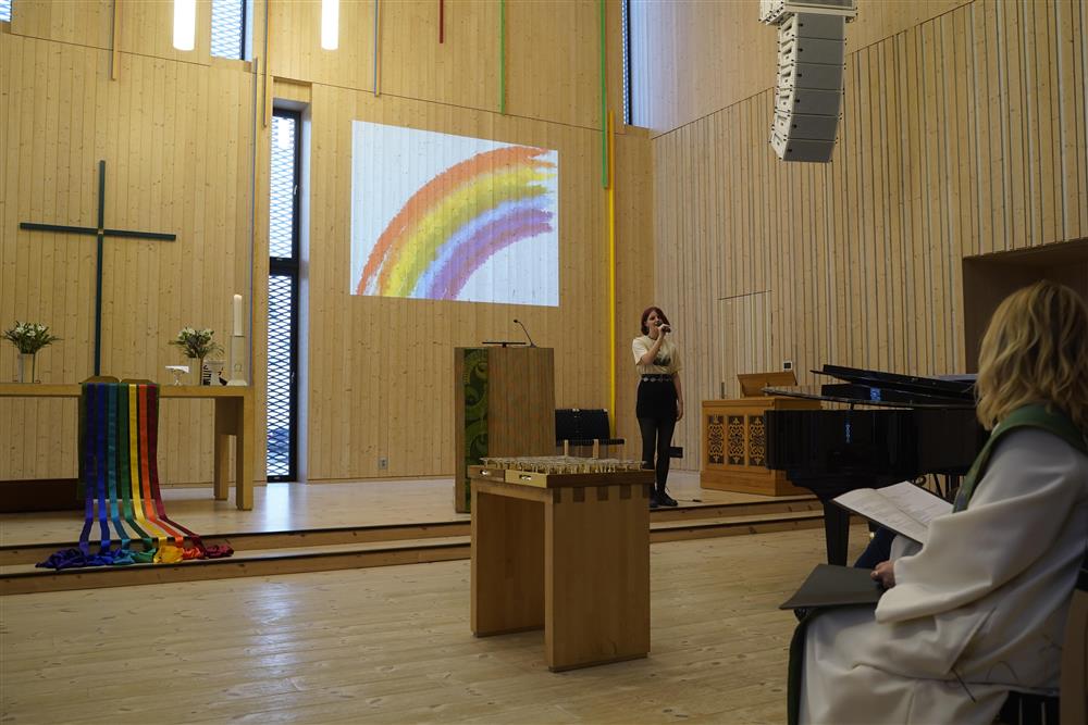 Sanne som synger under regnbuemesse i kirken.  - Klikk for stort bilde