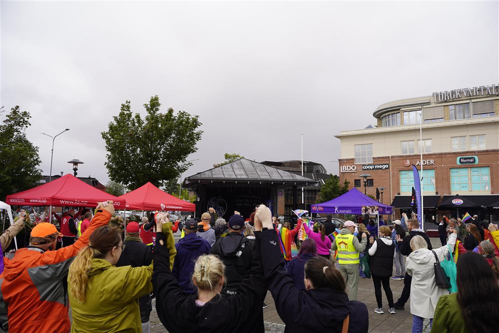 Masse folk som går i tog, med flagg, vimpler og mer. - Klikk for stort bilde