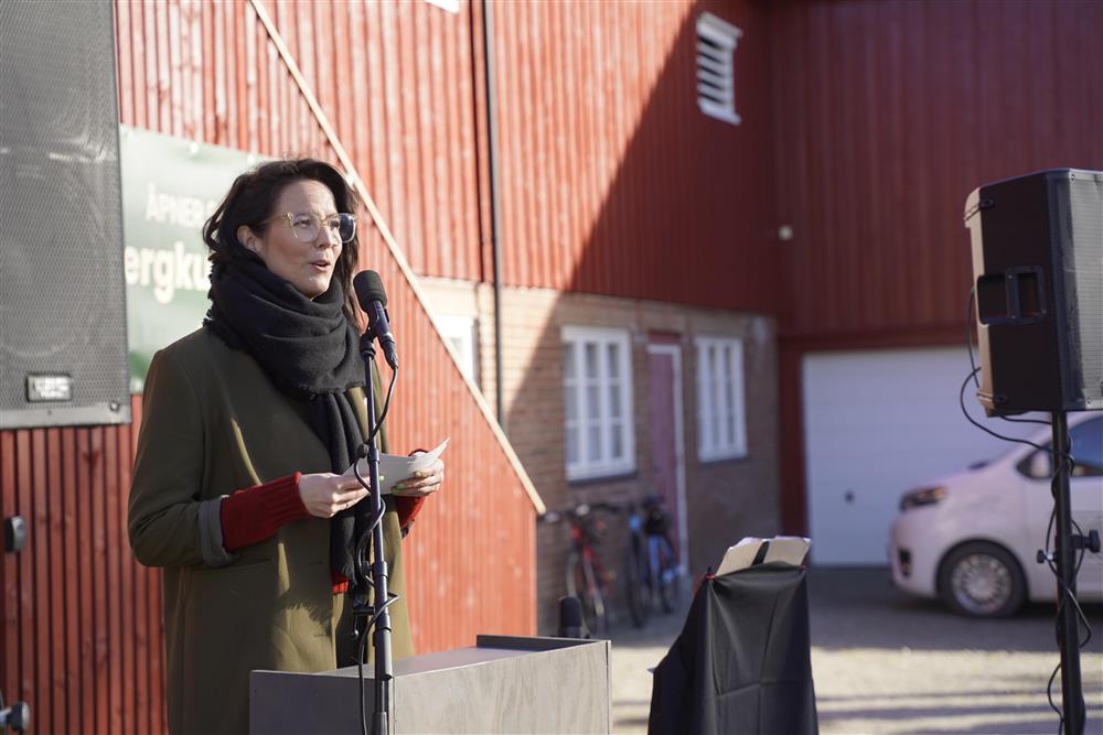En dame som holder tale utenfor Bergkunsetsenteret. Det er sol og hun prater i mikrfonen.  - Klikk for stort bilde