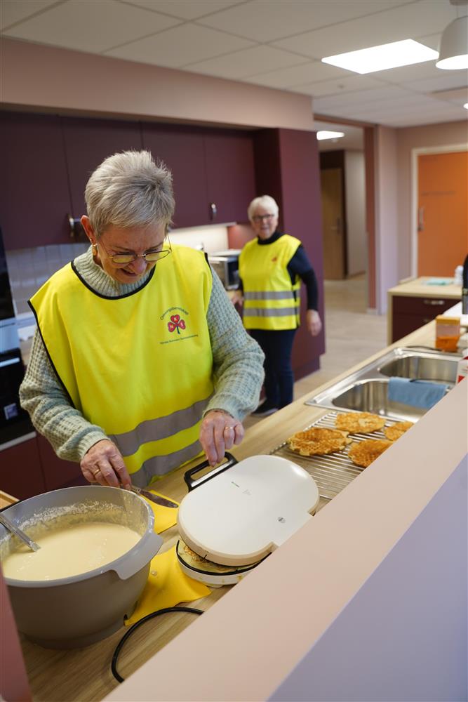 To damer fra NKS som lager vafler, en som står å steker en som fikser noe annet lengre inn på kjøkkenet.  - Klikk for stort bilde