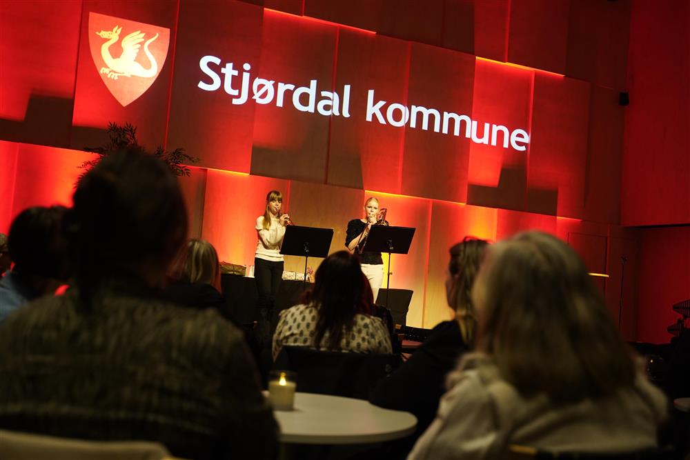 To jenter i 15års alderen som spiller på scenen foran mange ansatte.  - Klikk for stort bilde