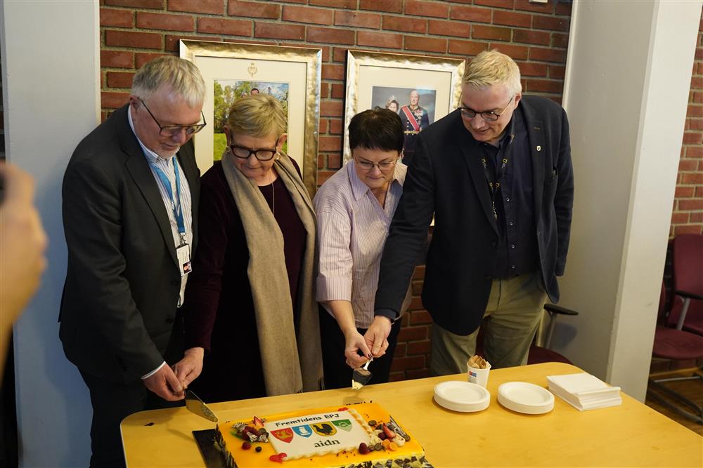 Alle ordførerene som kutter opp kake med kommunelogoene på. - Klikk for stort bilde