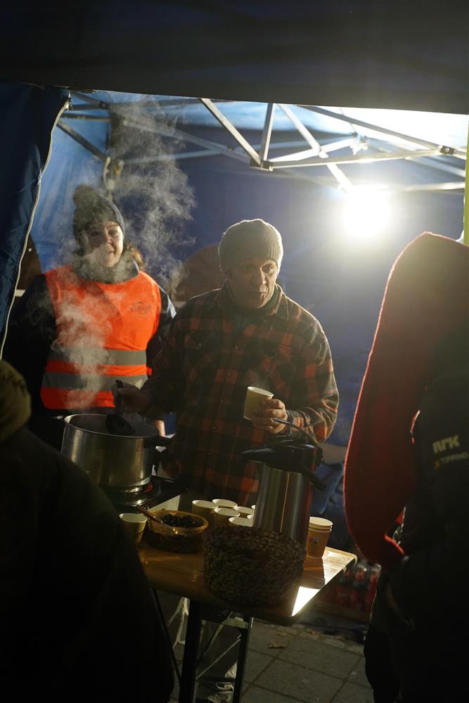 To frivillige fra frivilligsentralen gir ut gløgg, pepperkaker og nøtter fra telte sitt. - Klikk for stort bilde