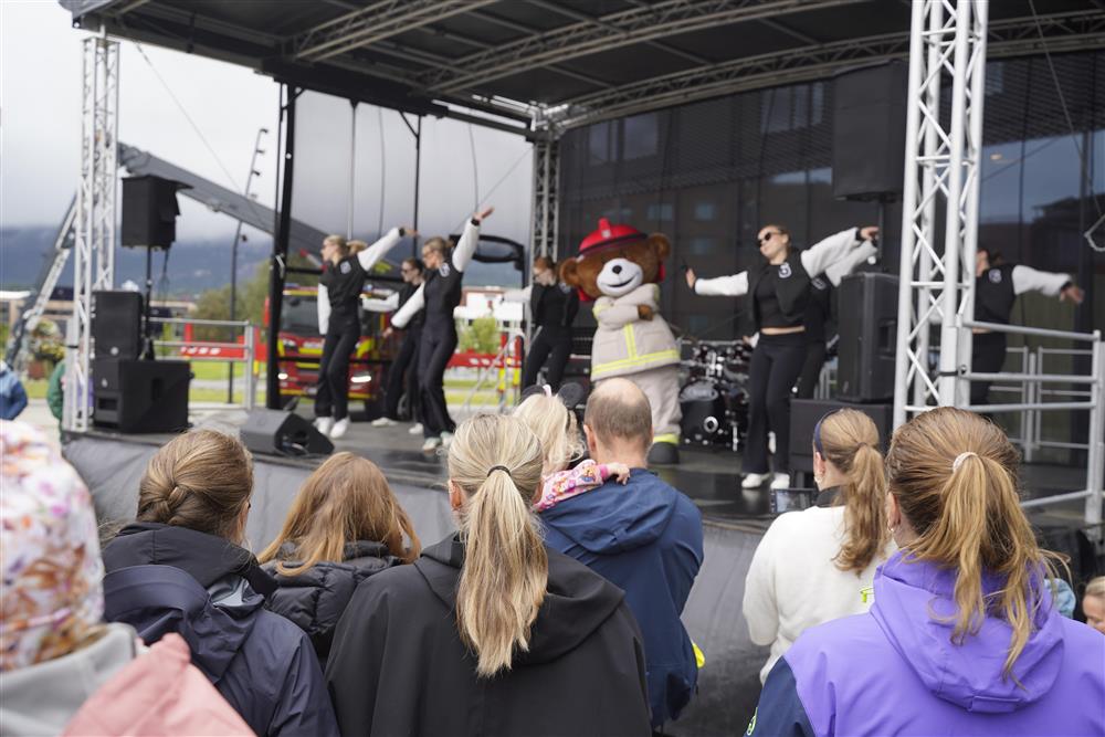 Bjørnis og 9 kvinnlige dansere på scenen utenfor Kimen Kulturhus. Det er fult av publikum foran scenen. - Klikk for stort bilde