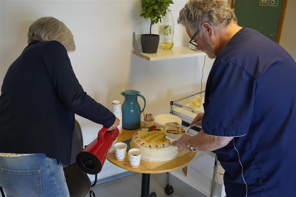 To ansatte som forsyner seg med kake og kaffe - Klikk for stort bilde