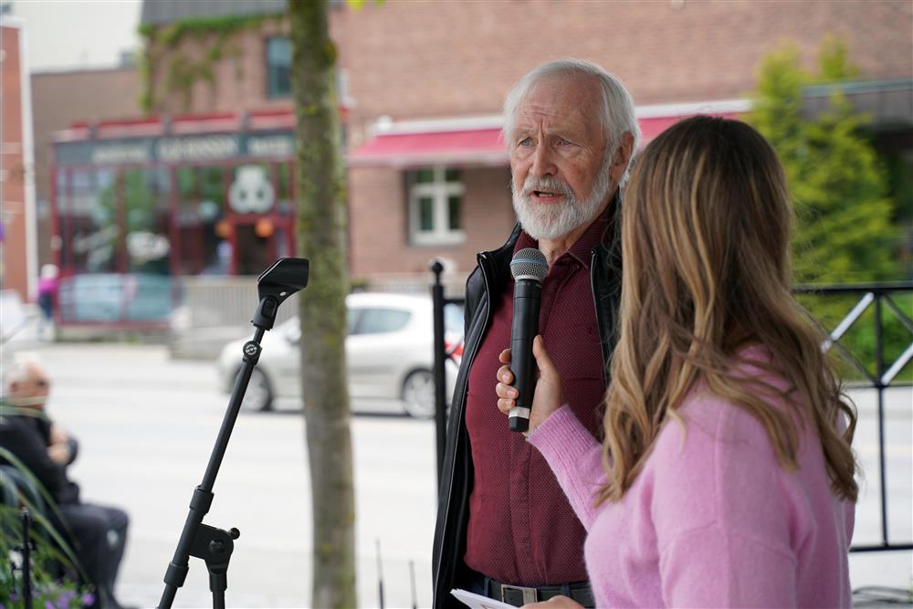 En mann blir intervjuet av en kvinne med mikrofonen, de er i paviljongen på torget.  - Klikk for stort bilde